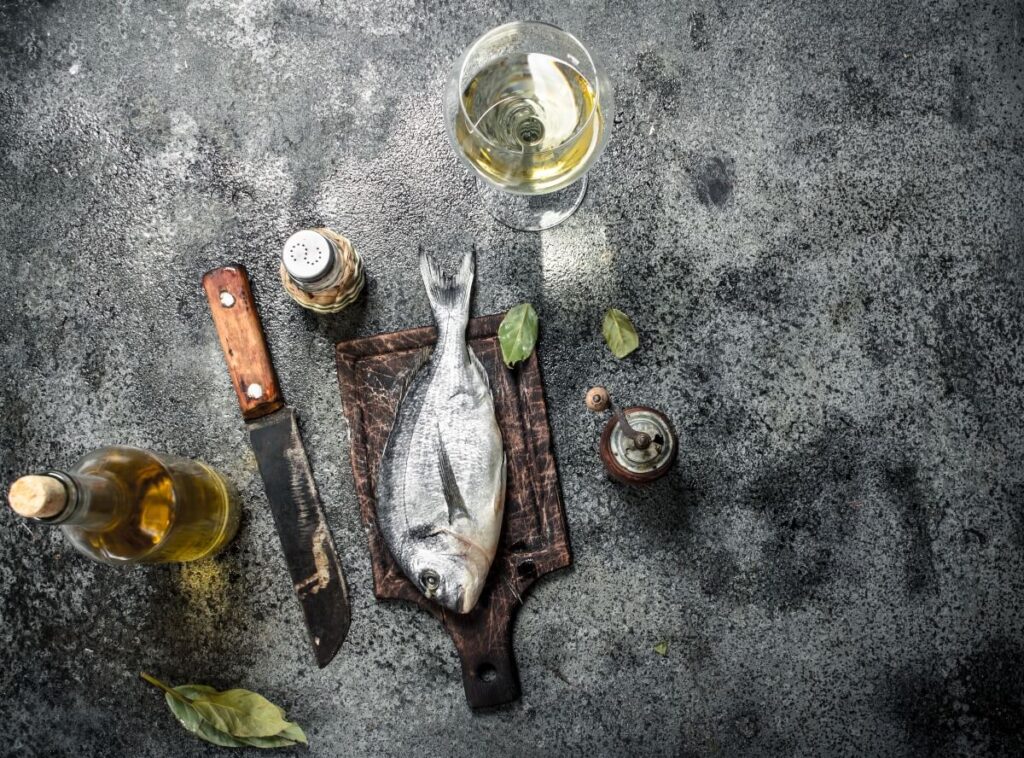 Sea bass with accompaniments and a cold glass of white wine